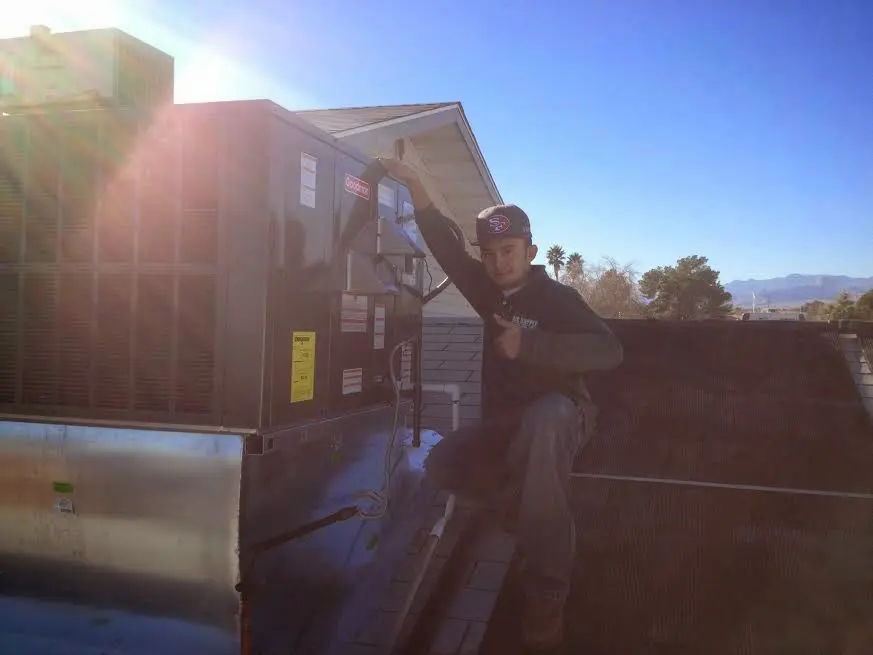 HVAC technician performing AC Tune-Up on a rooftop unit in Westmont
